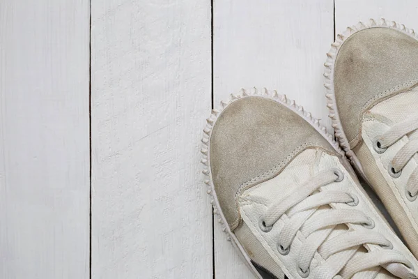 Old sneakers on white wooden floor background. — Stock Photo, Image