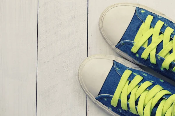 Old sneakers on white wooden floor background. — Stock Photo, Image