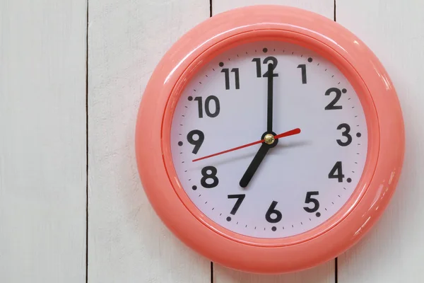 Horloge orange placer sur un plancher de bois blanc . — Photo