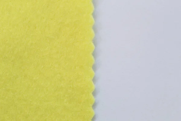 Tejido amarillo claro sobre papel blanco y espacio de copia para desig — Foto de Stock