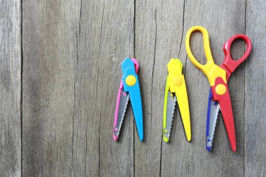 Plastik makas kahverengi ahşap üzerine Lay.