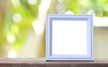 Modern resim çerçevesi bir ahşap zemin üzerinde yer.