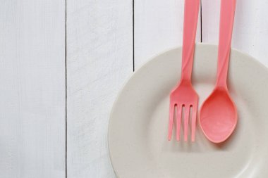 Tabak ve kaşık Beyaz ahşap zemin üzerinde.