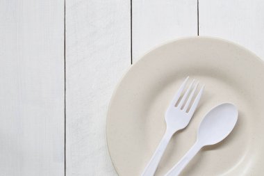 Tabak ve kaşık Beyaz ahşap zemin üzerinde.