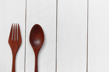 Tahta kaşık ve Beyaz ahşap zemin üzerinde ahşap çatal.