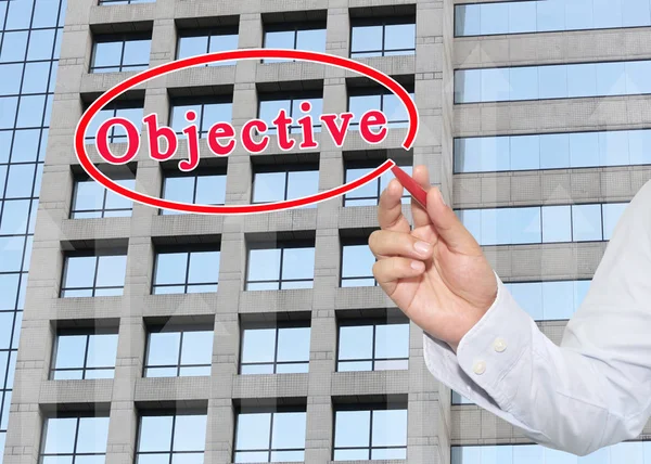 hand of businessman using red pen pointing to text of objective