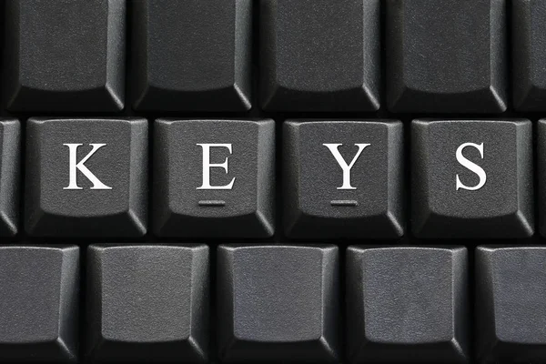 Bílé písmeno klíče na pozadí klávesnice počítače. — Stock fotografie