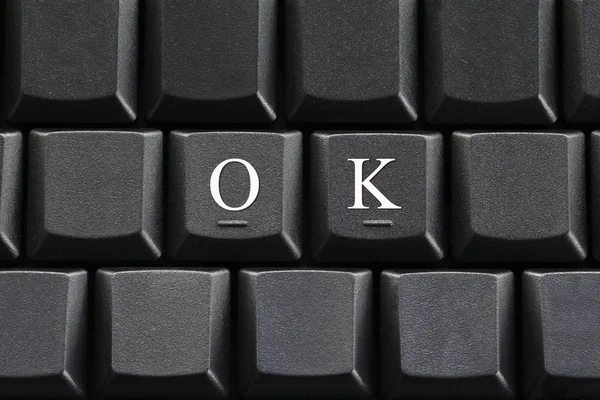 Белая буква OK на фоне клавиатуры компьютера . — стоковое фото