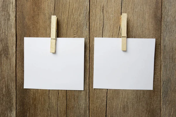 Kladblok met een houten klem op houten achtergrond. — Stockfoto