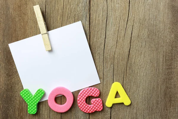 The Alphabet of Yoga Lay on old brown wood floor background.