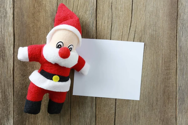 圣诞老人玩偶在木背景并且有笔记纸拷贝 s — 图库照片