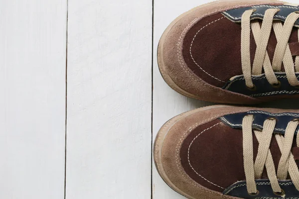 Beyaz ahşap zemin zemin üzerine eski spor ayakkabı. — Stok fotoğraf