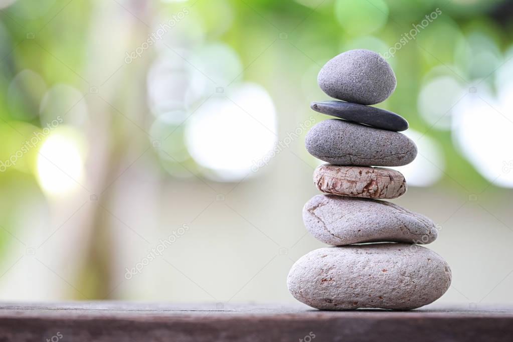 Balance Stones stacked to pyramid in the soft nature green backg