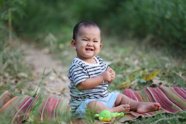 Asyalı çocuk çocuk Tay mat bahçede oturmak.