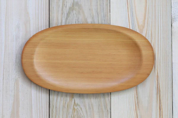 Дерев'яна тарілка порожня на дерев'яній підлозі і має місце для копіювання . — стокове фото