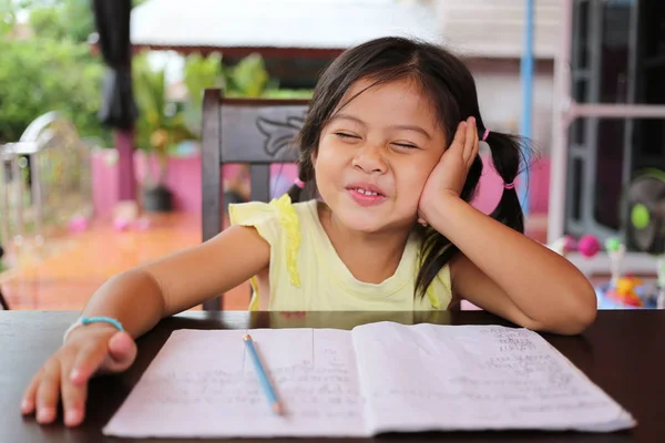 Asian child girl use Pencil write letters on the book. — Stock Photo, Image