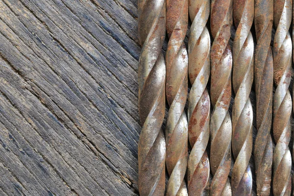 Viejo taladro de acero colocado en un suelo de madera marrón . — Foto de Stock