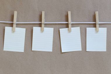 Not defteri asılı bir ip ve kahverengi kağıt arka plan boş.