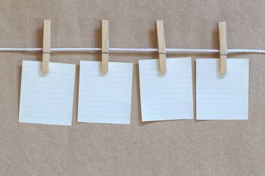 Not defteri asılı bir ip ve kahverengi kağıt arka plan boş.