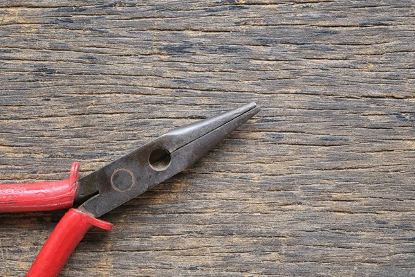 Old pliers placed on a wooden floor. — Stock Photo, Image