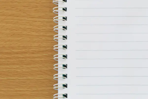 Svart linje på tom anteckningsbok placeras på en brun trä golv. — Stockfoto