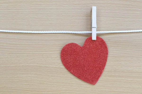 Rotes Herz hängt an einem Seil und hat Kopierraum auf braunem Rücken — Stockfoto
