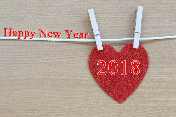 Corazón rojo colgando de una cuerda y tener texto feliz año nuevo . — Foto de Stock