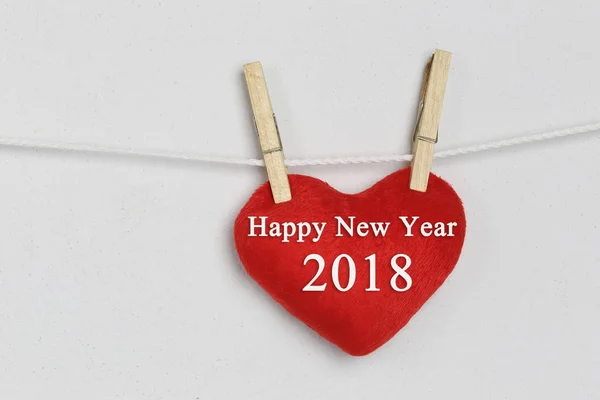 Corazón rojo colgando de una cuerda y tener texto feliz año nuevo . — Foto de Stock