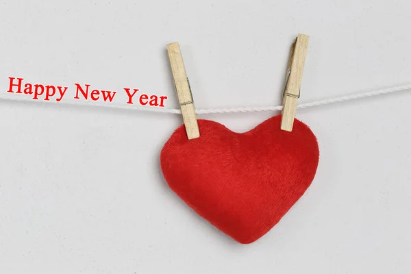 Corazón rojo colgando de la cuerda y tienen Feliz año nuevo texto . —  Fotos de Stock