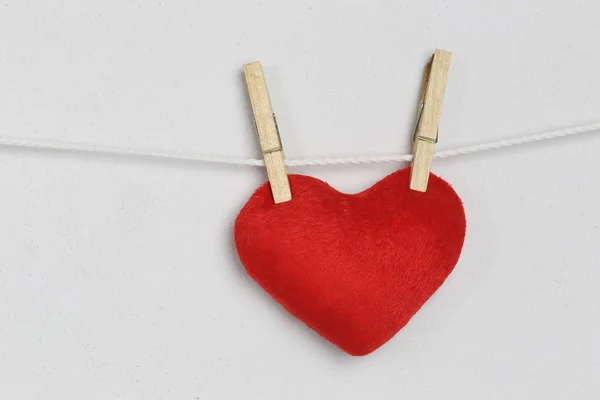 Corazón rojo colgando de una cuerda y tener espacio de copia en el fondo gris — Foto de Stock
