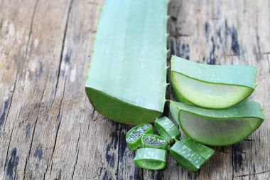 Ahşap zemin üzerinde taze Aloe Vera dilimlenmiş.