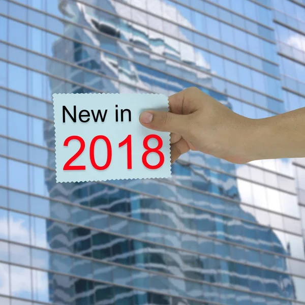 Hand of the businessman holding a paper note with new in 2018 te — Stock Photo, Image