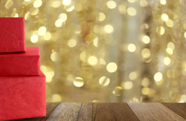 Red gift box on wooden floor and have gold bokeh background. — Stock Photo, Image
