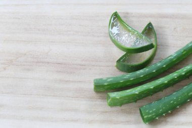 Ahşap zemin üzerinde taze Aloe Vera dilimlenmiş.
