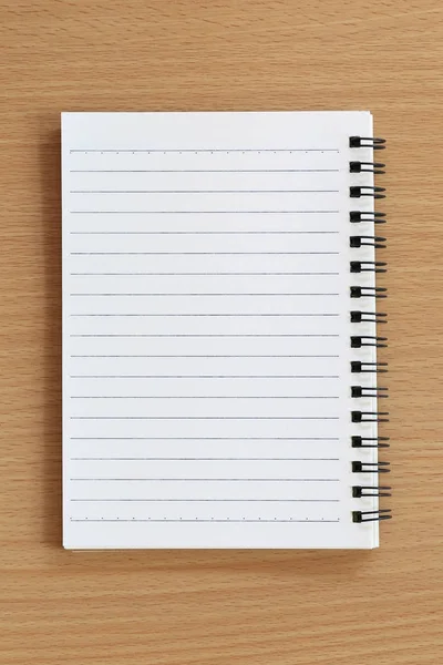 Puste notebook jest umieszczony na brązowy stół z drewna. — Zdjęcie stockowe