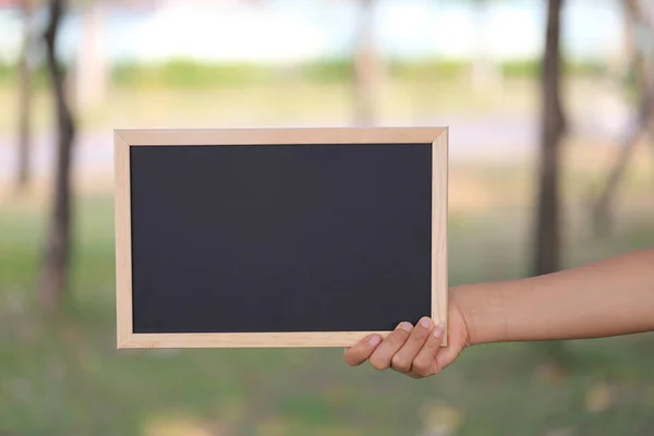 Hand einer Geschäftsfrau mit einem leeren schwarzen Holzbild — Stockfoto
