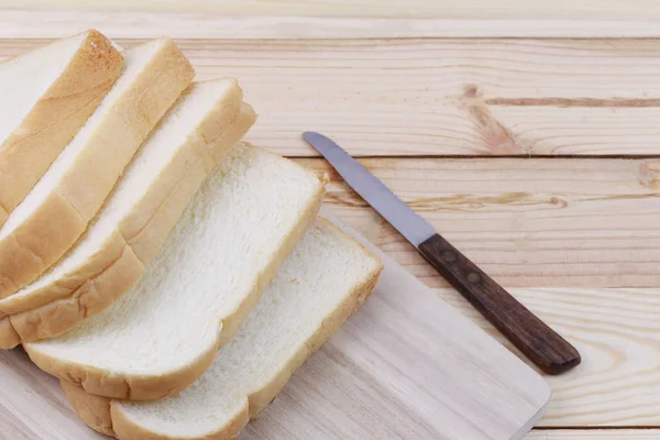 Brot in Scheiben gestapelt auf einem hölzernen Schneidebrett. — Stockfoto