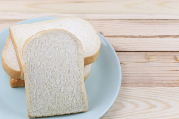 Scheibenbrot in grüner Schüssel auf Holzboden gestapelt. — Stockfoto