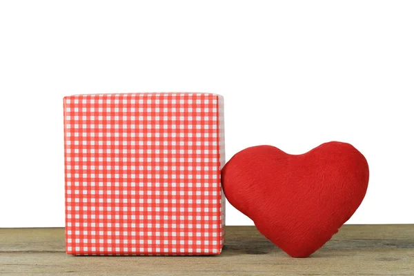 Красное сердце и коробка для подарков на деревянном полу на белом бэкграунде — стоковое фото