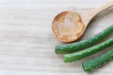 Ahşap zemin üzerinde taze Aloe Vera dilimlenmiş.