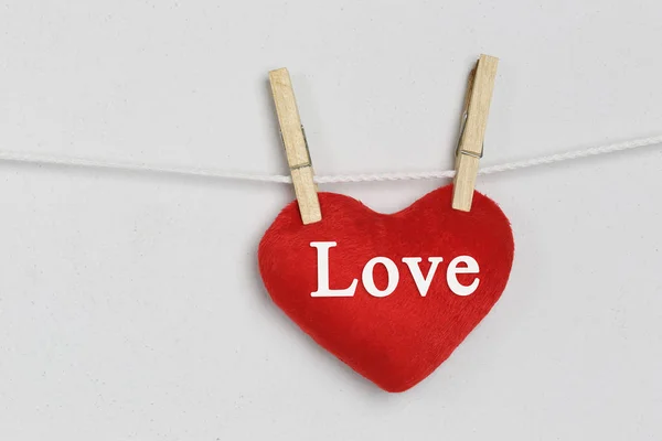 Red heart hanging on a rope and have Love text. — Stock Photo, Image