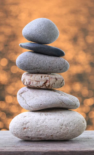 Balance Stones stacked to pyramid on wooden floor in the soft Or