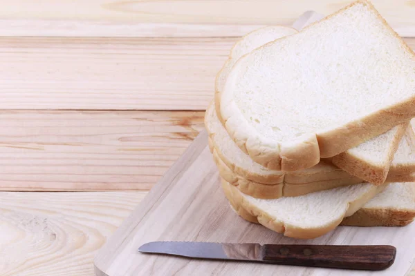 Brot in Scheiben gestapelt auf einem hölzernen Schneidebrett. — Stockfoto