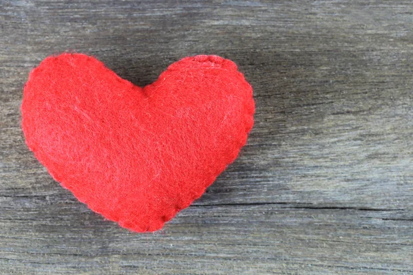 Coração vermelho é colocado em um piso de madeira marrom . — Fotografia de Stock
