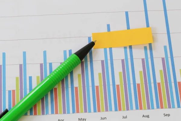 Green pen pointing to the data of business graph background and — Stock Photo, Image