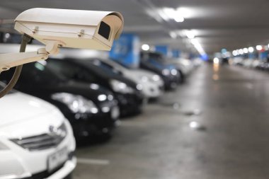 CCTV Camera on blurred cars parking and bokeh light. clipart