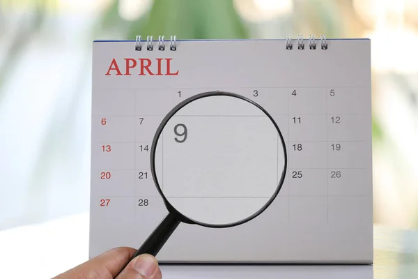 Glas in hand uitvergroten op kalender kun je negende dag van m — Stockfoto