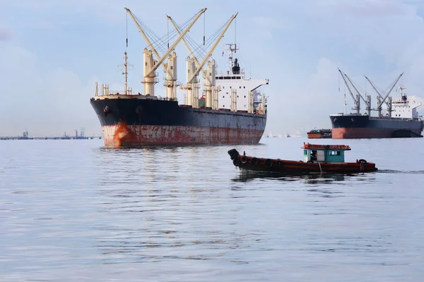 Kleine personenauto boot in de zee lopen en hebben vrachtschip. — Stockfoto