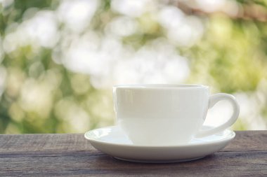 Beyaz kahve fincanı bir kahverengi ahşap zemin yerleştirilir.