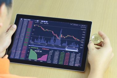 İşadamı ve dijital grafik tablet elinde altın bitcoin 